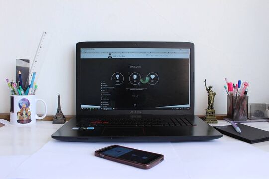 Bureau avec un ordinateur, un téléphone et des stylos